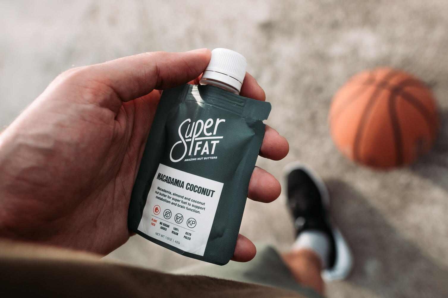 Hand holding nut butter package basketball court concept Hand holding nut butter package basketball court concept